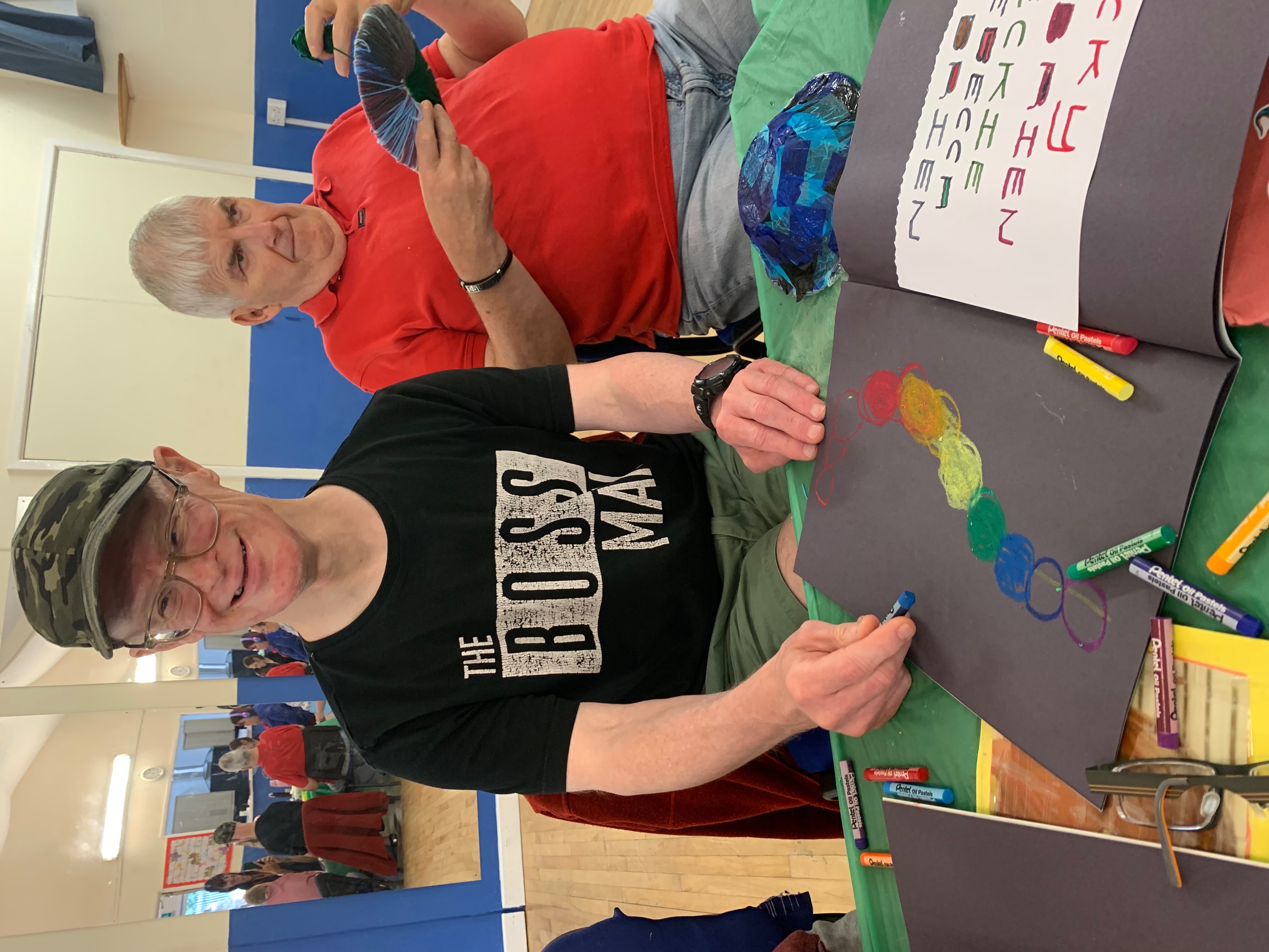 Participant creating colorful circle patterns on dark paper