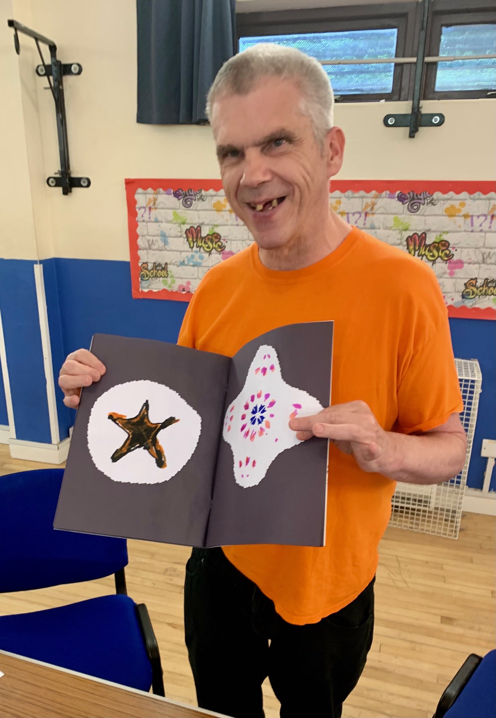 Participant proudly showing artwork featuring starfish and creative designs